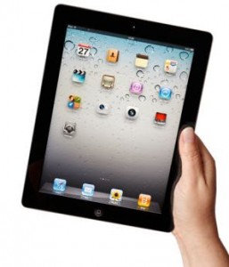 C7RP8J Hand holding iPad 2 showing applications menu screen